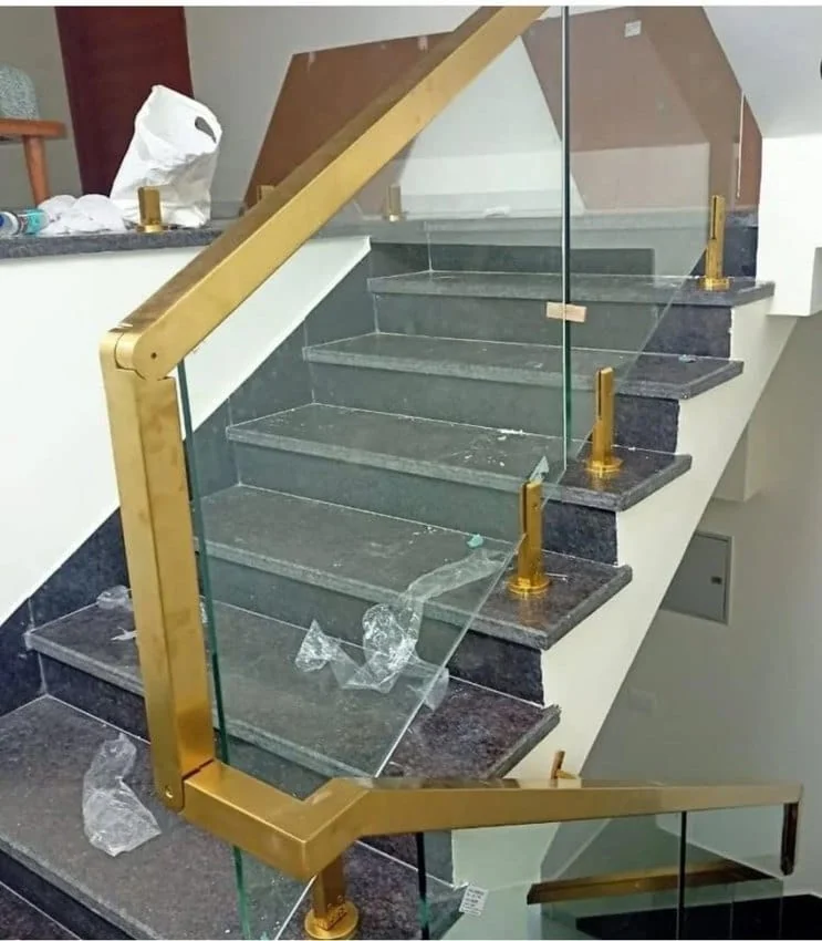 Staircase glass with gold-tone handrail